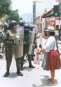 An indigenous Bolivian confronts a line of armed police during protests against globalisation in the country.