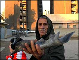 An Iraqi shows shrapnel left after the latest resistance strike near his home in Baghdad.